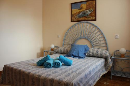 a bedroom with a bed with blue pillows on it at Riumar "Camins", 380m to beach, private pool, On-Site-Service, dog beach in Riumar