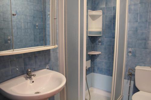 a blue tiled bathroom with a sink and a toilet at Riumar "Camins", 380m to beach, private pool, On-Site-Service, dog beach in Riumar