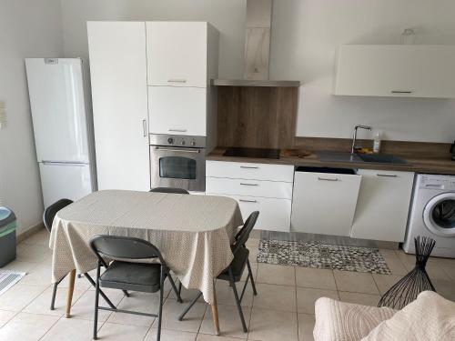 eine Küche mit einem Tisch und Stühlen in der Unterkunft Location gîte campagne en Provence - Vaucluse in Pernes-les-Fontaines