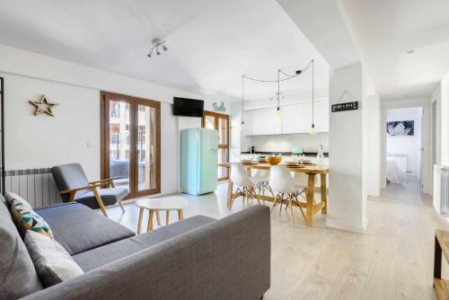 ein Wohnzimmer und eine Küche mit einem Sofa und einem Tisch in der Unterkunft Casa Lobo Panticosa in Panticosa
