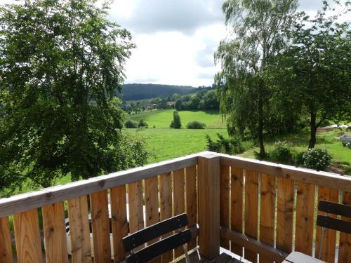 a deck with two benches and a view of a field at Fewo Im gruenen Eck 2 in Airlenbach