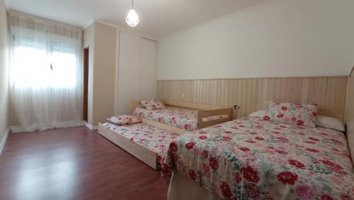 1 Schlafzimmer mit 2 Betten und einem Fenster in der Unterkunft O Lagar apartamento grande y luminoso. 8 personas. in Pobra do Caramiñal