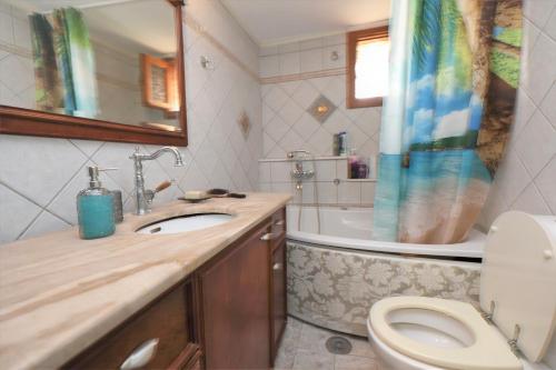 La salle de bains est pourvue d'un lavabo, de toilettes et d'une baignoire. dans l'établissement Endless Blue Sea Frontal house, à Palaiokastro