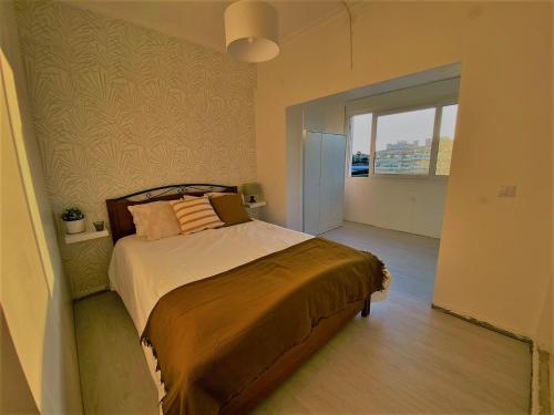- une chambre avec un lit et une grande fenêtre dans l'établissement NS GuestHouse, à Armação de Pêra