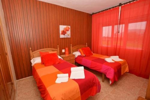 2 camas en una habitación con rojo y naranja en Villa Cancillo - 6802, en Noja