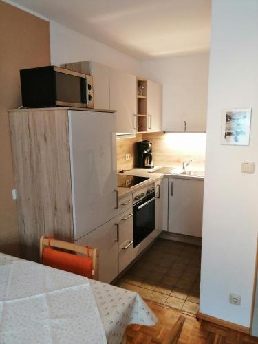eine kleine Küche mit einem Herd und einer Mikrowelle in der Unterkunft Ferienwohnung Jenny in Schruns-Tschagguns