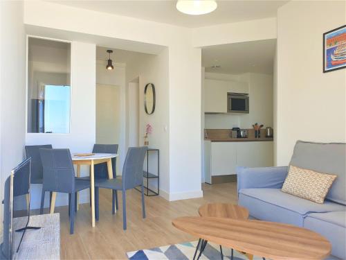 un salon avec un canapé bleu et une table dans l'établissement Promenade vue mer, à Nice