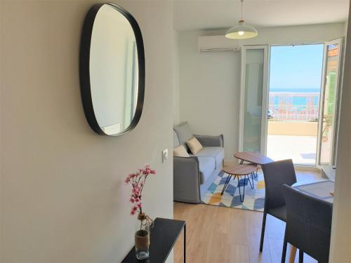 - un salon avec un miroir et un canapé dans l'établissement Promenade vue mer, à Nice