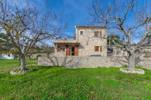 an exterior view of a stone house with trees at YourHouse Son Sant Joan in Alaró