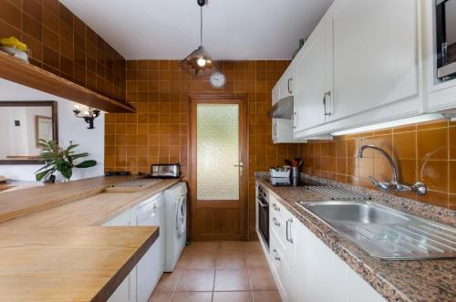 a kitchen with white cabinets and a sink at YourHouse Son Sant Joan in Alaró