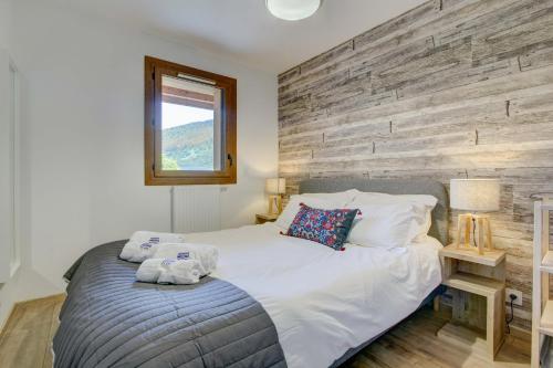 une chambre avec un lit et un mur en bois dans l'établissement Les Bailicîmes - Snow and Trek, à Morzine