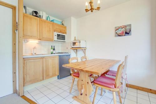 une cuisine avec une table et des chaises en bois dans l'établissement Mitoulets 3 40 - Snow and Trek -Morzine, à Morzine