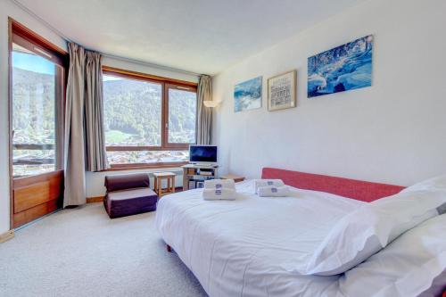 une chambre d'hôtel avec un lit et une grande fenêtre dans l'établissement Mitoulets 3 40 - Snow and Trek -Morzine, à Morzine
