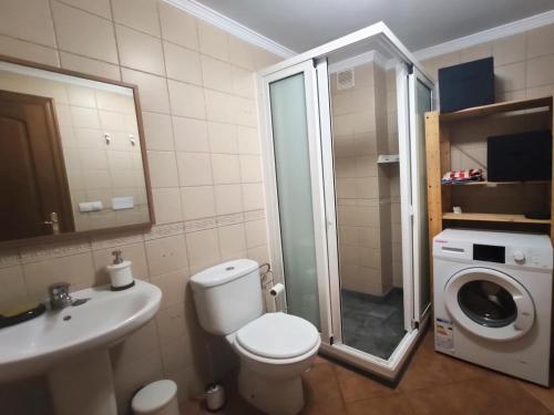 uma casa de banho com um WC, um lavatório e uma máquina de lavar roupa em La Chalana em Arrecife
