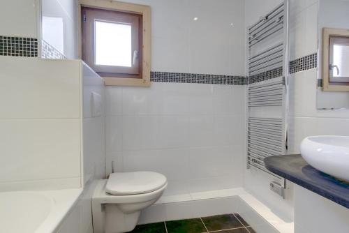 a white bathroom with a toilet and a sink at Beziere - Snow and Trek in Morzine
