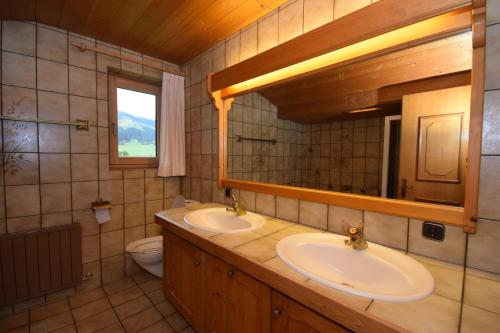 a bathroom with two sinks and a mirror and a toilet at Apartment Brandstätter 1 & 2 by Apartment Managers in Brixen im Thale