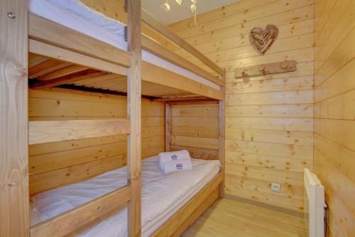 a bedroom with two bunk beds in a log cabin at Slalom Apartment - Very Town Centre - Snow and Trek - Morzine in Morzine