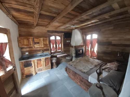 a bedroom with a bed and a sink and wooden walls at Chalet MariBru in Pradleves