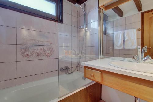 ein Bad mit einer Badewanne, einem Waschbecken und einer Dusche in der Unterkunft La Corniche in Morzine