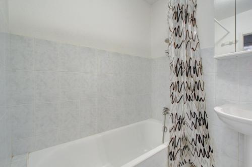 La salle de bains est pourvue d'un rideau de douche avec des animaux. dans l'établissement Les Nants - Snow and Trek, à Morzine