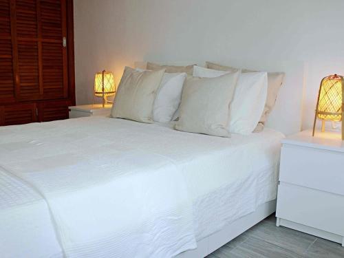 プラヤ・オンダにあるPlaya Honda Homeのベッドルーム1室(白いベッド1台、ランプ2つ付)