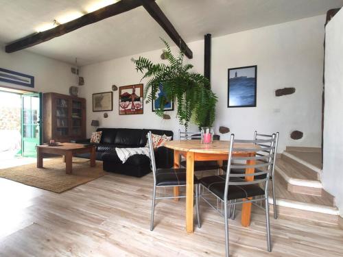 sala de estar con mesa de madera y sillas en Roca redonda, en Haría