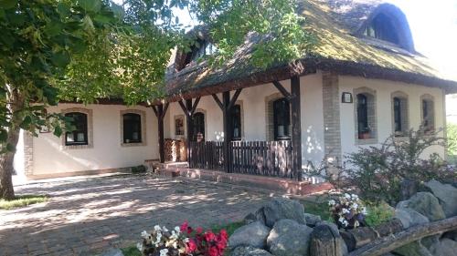 una casa con techo de paja y patio en Hajóskert Vendégház, en Gönyů