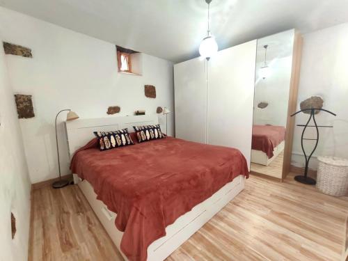 1 dormitorio con 1 cama grande con manta roja en Roca redonda, en Haría