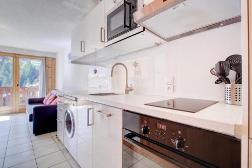 une cuisine blanche avec un évier et un lave-vaisselle dans l'établissement Castors - 2 bedroom apartment - Snow and Trek, à Morzine