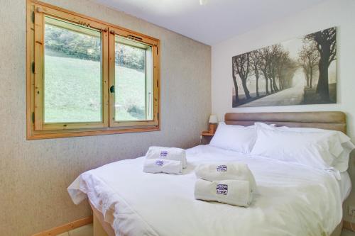 une chambre avec un lit avec deux serviettes dessus dans l'établissement Castors - 2 bedroom apartment - Snow and Trek, à Morzine