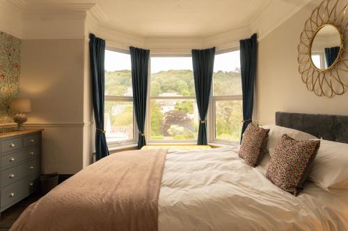 a bedroom with a bed and a large window at Langleigh Villa in Ilfracombe