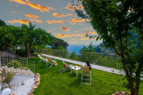 a yard with chairs and a view of the ocean at B&B Casanova in Agerola