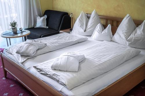two beds with white sheets and a chair in a room at DAS Hintersee in Hintersee