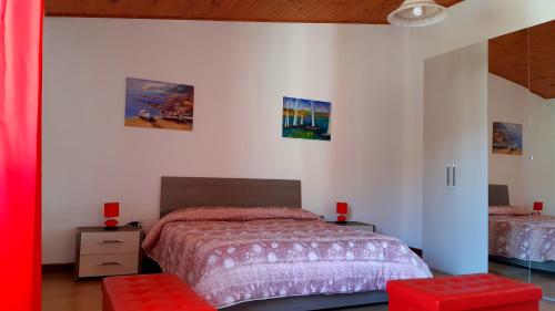 um quarto com uma cama e dois bancos vermelhos em Mare&Monti em Telti