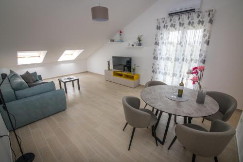 ein Wohnzimmer mit einem Sofa und einem Tisch in der Unterkunft Apartment Skylight in Kostrena
