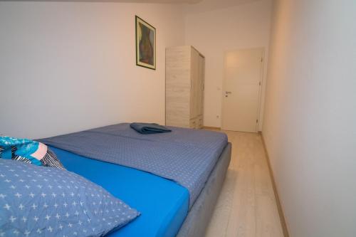 a bedroom with a blue bed and a closet at Apartment Skylight in Kostrena