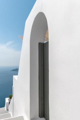 a door in the side of a white building at Kasimatis by La Perla - Adults Only in Imerovigli