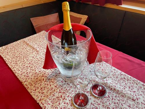 a bottle of wine is sitting on a table with two glasses at Villa Anita San Vigilio di Marebbe in San Vigilio Di Marebbe