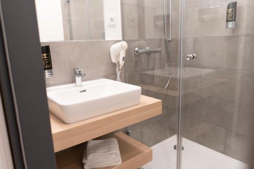 a bathroom with a sink and a shower at Signature Hotel Skarv in Elmshorn