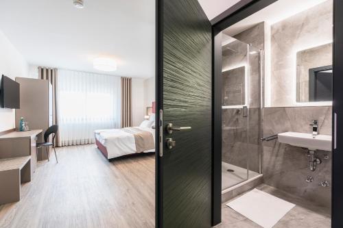 a bathroom with a shower and a toilet and a sink at Mix Hotel Limburg in Limburg an der Lahn