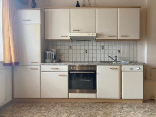 a kitchen with white cabinets and a stove top oven at Bloserhof Kaschmann in Zellberg