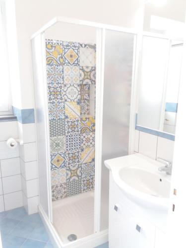 y baño con ducha y pared de azulejos. en GRomano Apartments, en Isquia