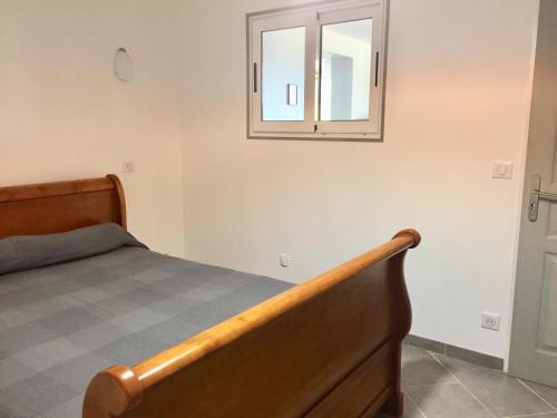 une chambre avec un lit et un miroir au mur dans l'établissement CASA CRISTINA Charmant Appartement CALME ENTRE MER ET MONTAGNE, à Santa-Lucia-di-Tallano