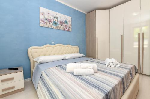 een slaapkamer met een groot bed en handdoeken bij My Desenzano Holiday Apartment in Desenzano del Garda