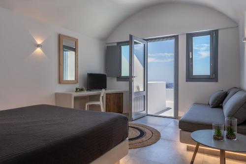 a hotel room with a bed and a tv at Kasimatis by La Perla - Adults Only in Imerovigli