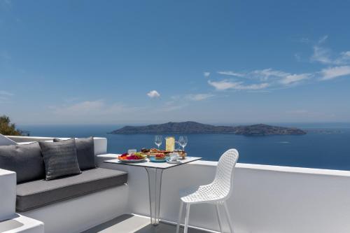 a balcony with a table and chairs and the ocean at Kasimatis by La Perla - Adults Only in Imerovigli