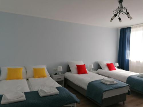 a living room with two beds with colorful pillows at Gladiator Noclegi Zator lV Apartament in Zator