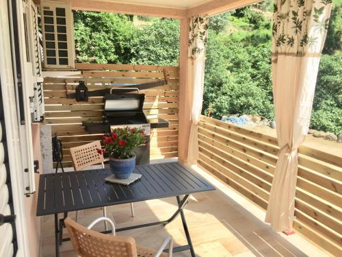 une véranda avec une table et des chaises dans l'établissement CASA CRISTINA Charmant Appartement CALME ENTRE MER ET MONTAGNE, à Santa-Lucia-di-Tallano