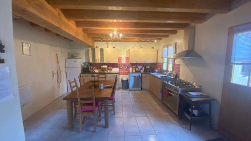 a large kitchen with a wooden table and chairs at Loire Escapes - Maison D'Hibou in Berrie