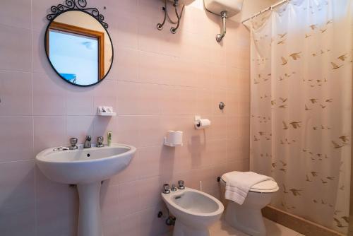 bagno con lavandino, servizi igienici e specchio di Casa Colletta Vieste a Vieste